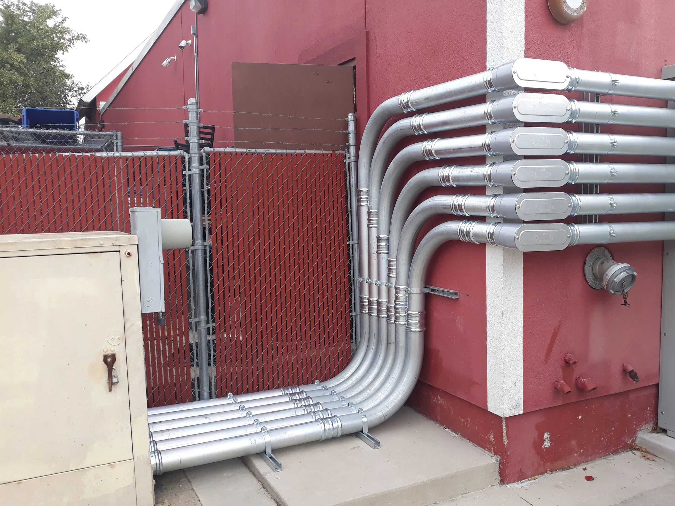 Industrial exterior pipes and conduit on brick building